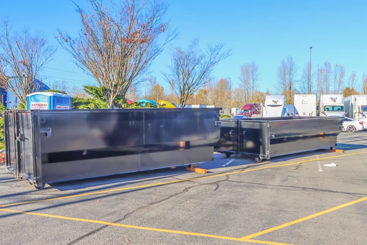 Professional dumpster rental service with roll-off container on residential driveway in White Hall